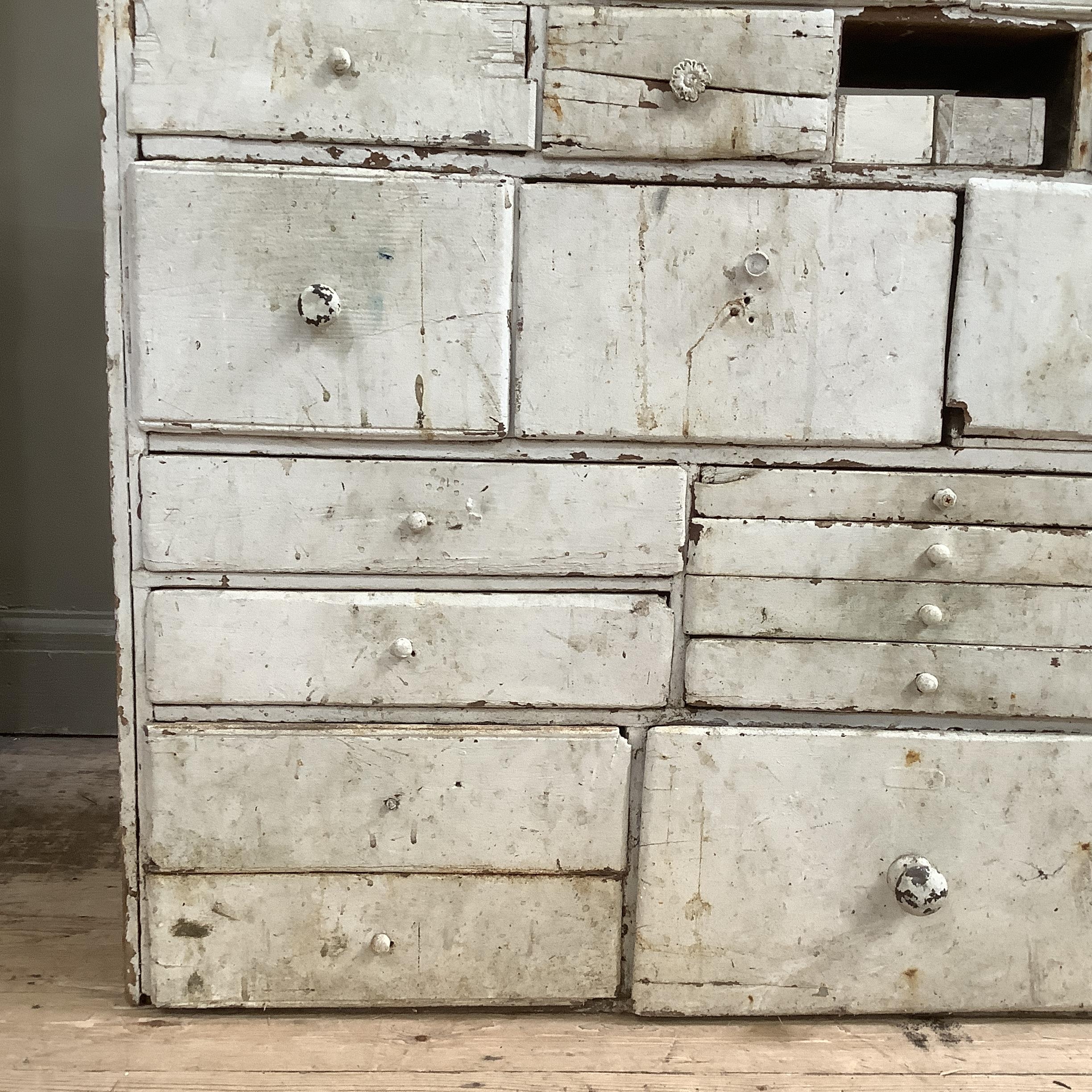 A late 19th/early 20th century set of chemist drawers in pine painted white, having numerous sized - Image 2 of 3