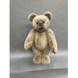 A very large teddy bear by Charlie Bears with pale blonde plush and black eyes, swivel head and