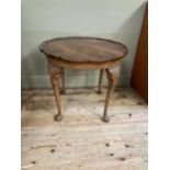 A walnut quarter veneered occasional table of circular outline with pie crust rim, shell and