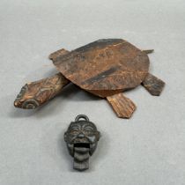 A wooden model of a turtle with a moving head and feet (one foot missing) together with a small