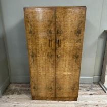 A 1930s gentleman's walnut wardrobe having two doors the interior fitted with two open