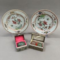 A pair of early 20th century famille rose plates painted to the centre with rocks issuing peony