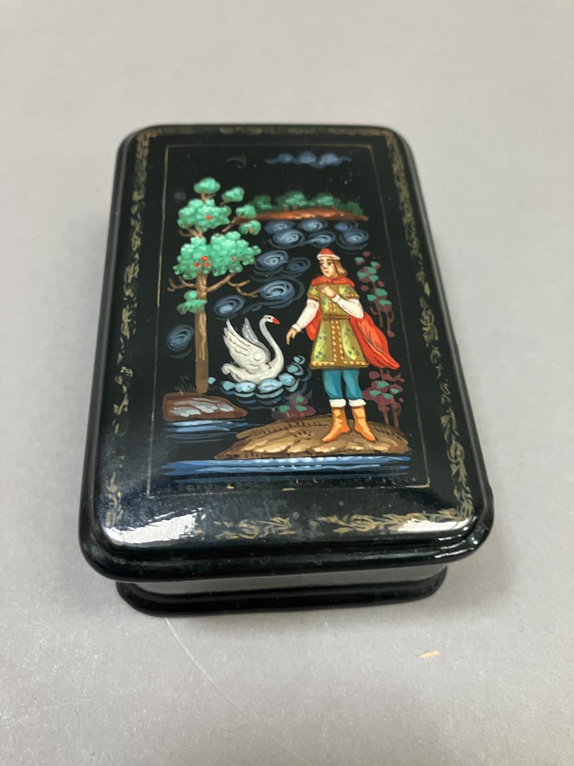 A Russian black lacquered trinket box, rectangular, the cover painted with a figure and swan, 8. - Image 2 of 5