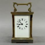 A gilt brass carriage clock, white enamel dial and black Roman numerals, 15cm over handle