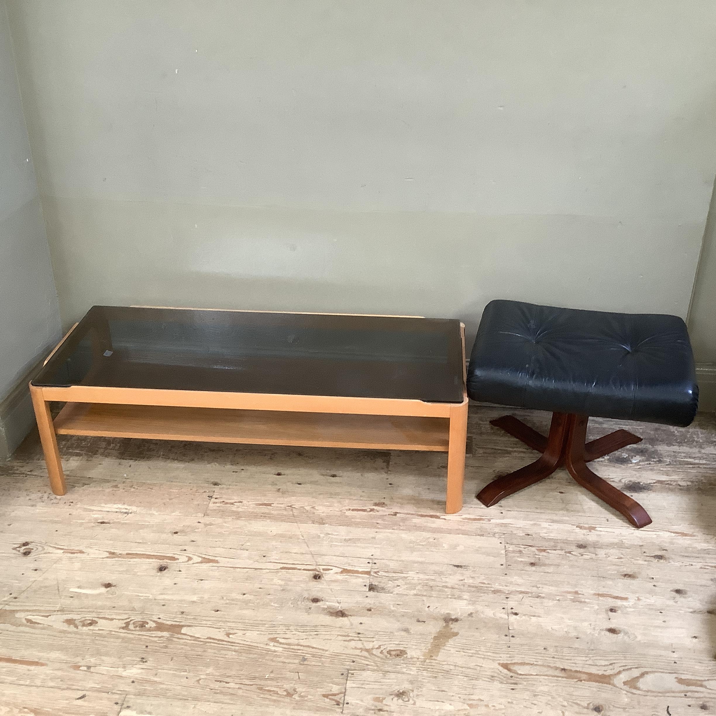 A smoked glass and teak two tier coffee table 112cm x 48cm x 35cm together with a Stressless style