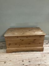 A modern pine blanket chest with brass cup handles and on plinth base, 97cm x 53cm x 50cm