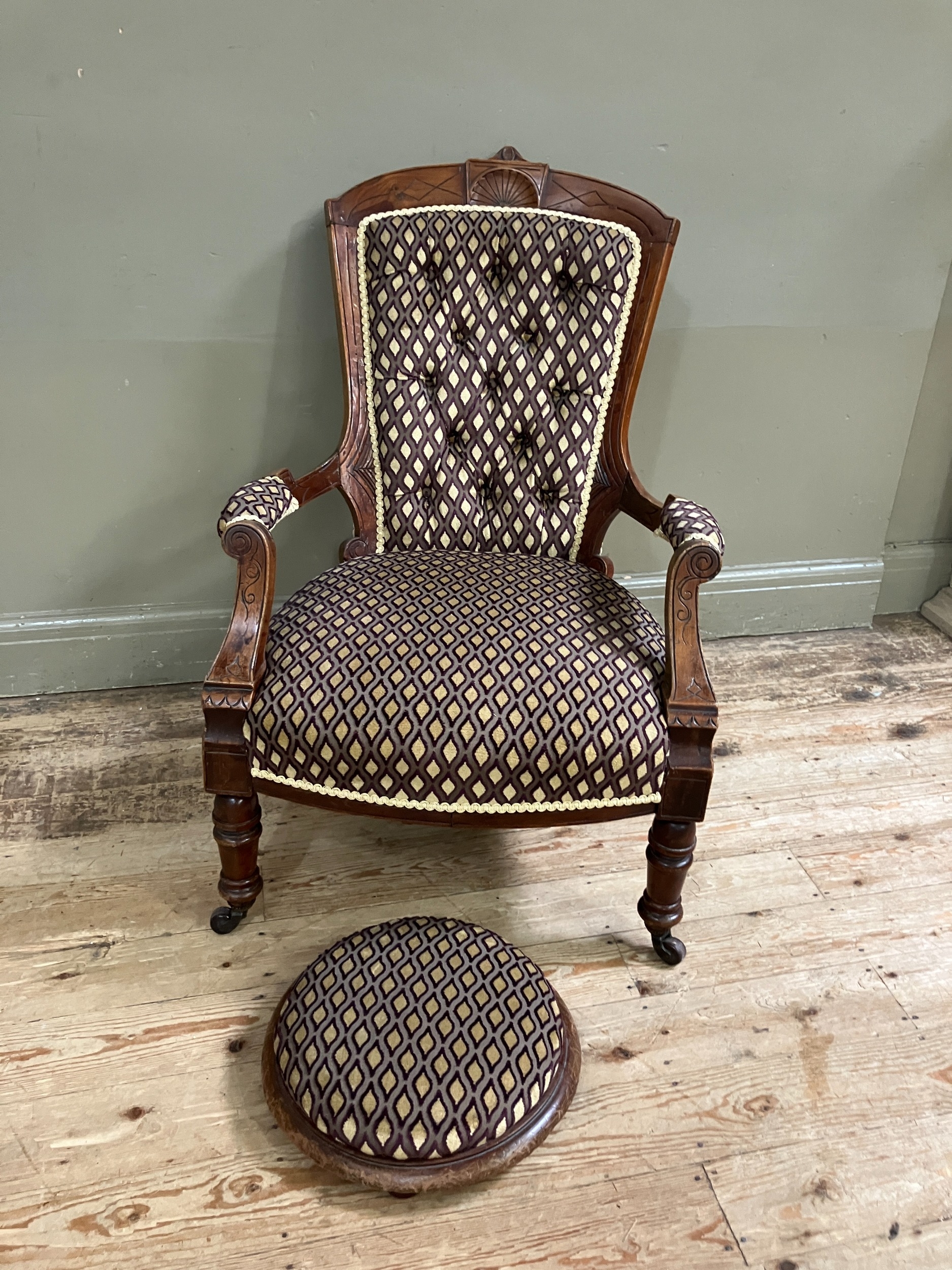 A late Victorian open armchair having an encircling frame with shell cresting, button upholstered