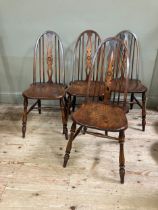 A set of four Glenister elm dining chairs with pierced splat and railed back on turned legs joined
