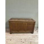 An oak blanket box having a triple indented panel top and conforming front on style feet, 108cm x