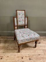 A late 19th century aesthetic walnut nursing chair having a rectangular stepped back inset with