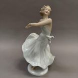 A German china figure of a girl in dance pose, on circular base, 26.5cm high