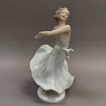 A German china figure of a girl in dance pose, on circular base, 26.5cm high