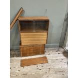 A 1970s style wall hanging unit comprising two shelves, a cupboard unit with sliding glass doors,