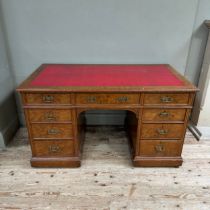 A Victorian oak kneehole desk having three drawers across and three further drawers to either side