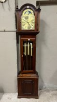 A reproduction mahogany longcase clock having an arched dial with moon phase, the chaptering with
