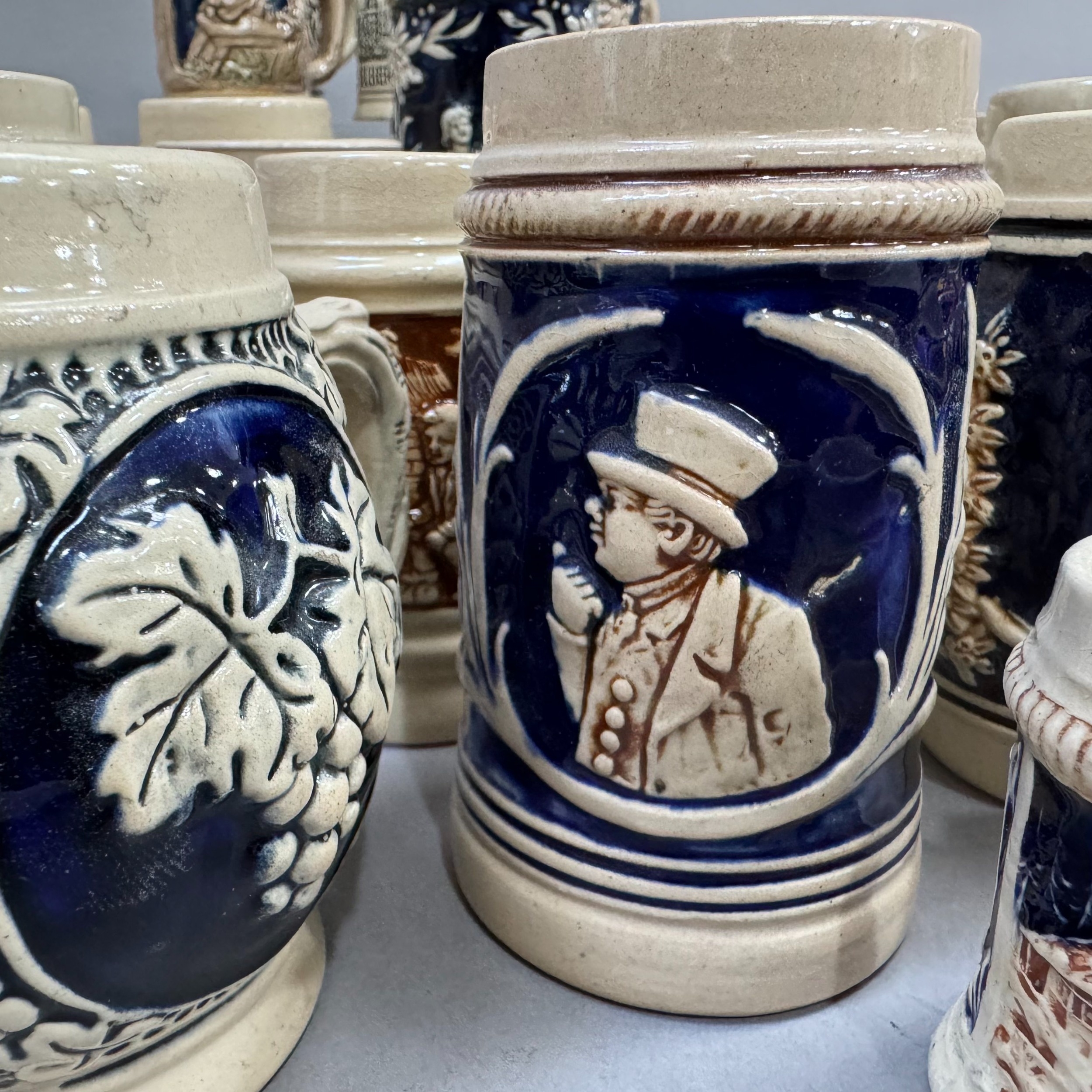 A large quantity of German pottery steins glazed in blue and with relief moulded scenes - Image 2 of 3