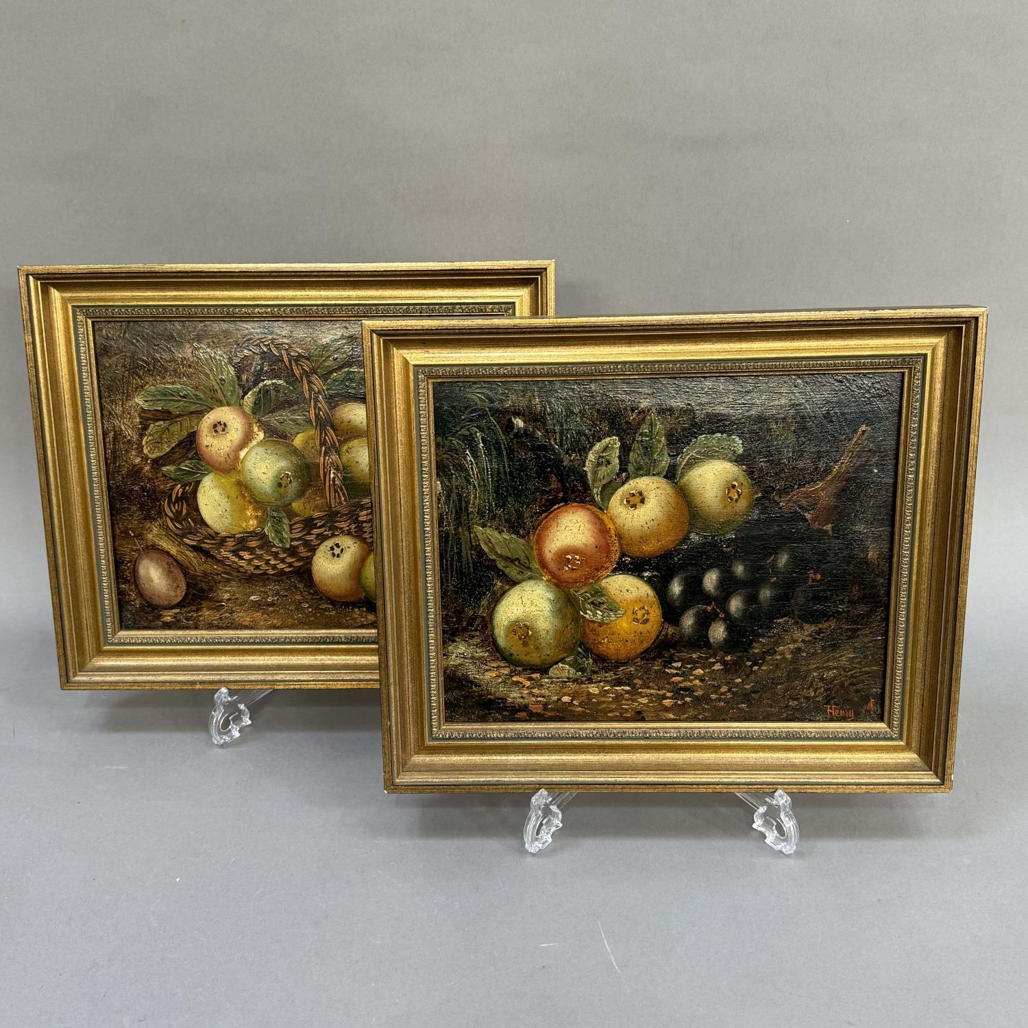 In the style of Henry Clare, a pair of still life of fruit, apples in a basket, apples and grapes