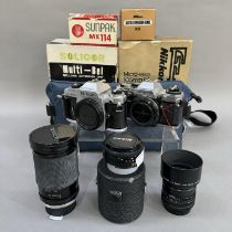 A Nikon FG manual film SLR camera with various lenses including Tamron zoom lens and Nikon 50mm