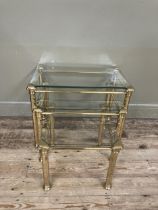 A set of three brass and glass coffee tables