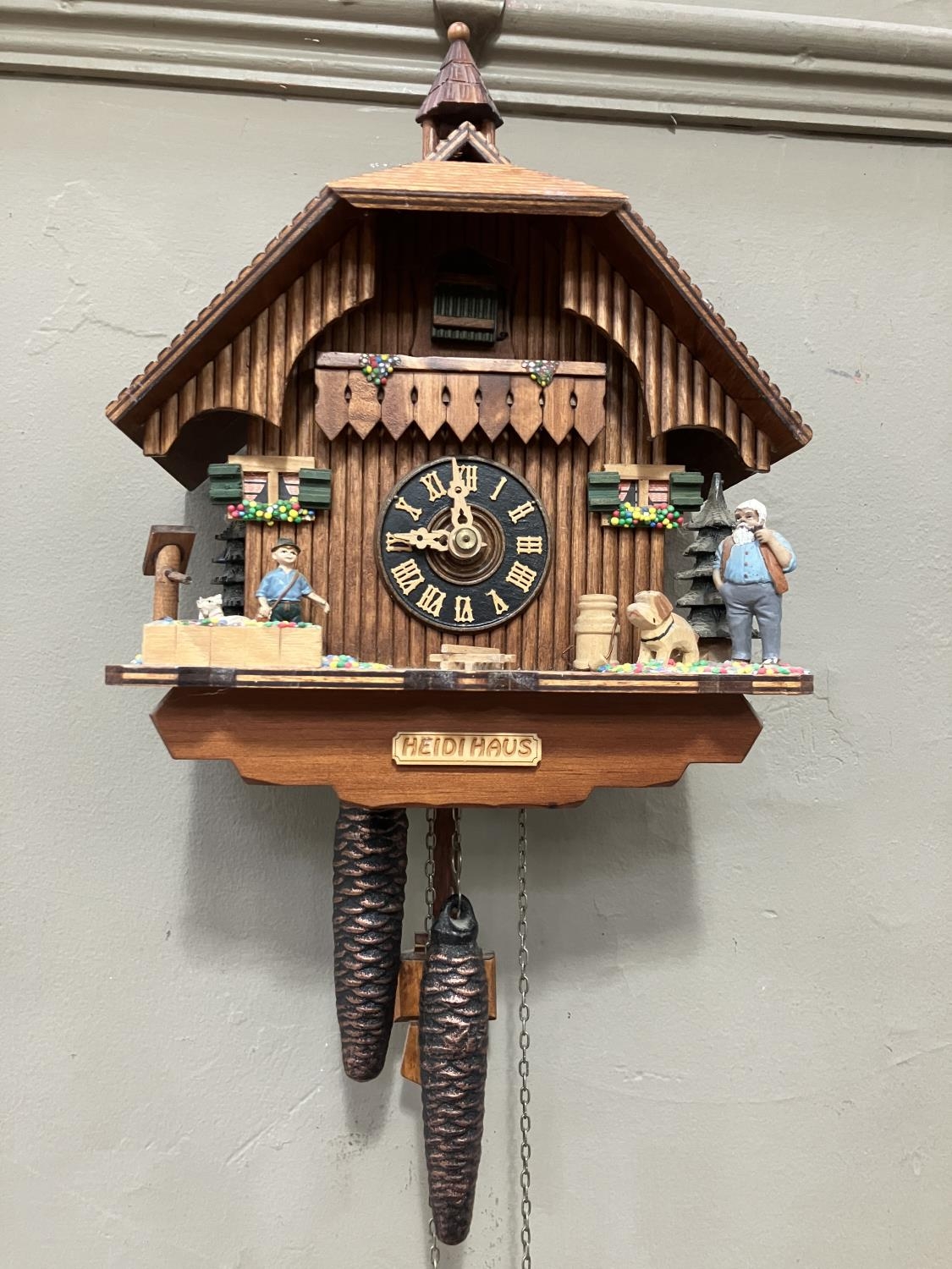 A Black Forest style cuckoo clock with swinging pendulum and weights having two figures , goats