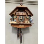 A Black Forest style cuckoo clock with swinging pendulum and weights having two figures , goats