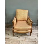 A reproduction French bergere style armchair having a moulded and encircling frame, floral cresting,