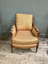 A reproduction French bergere style armchair having a moulded and encircling frame, floral cresting,