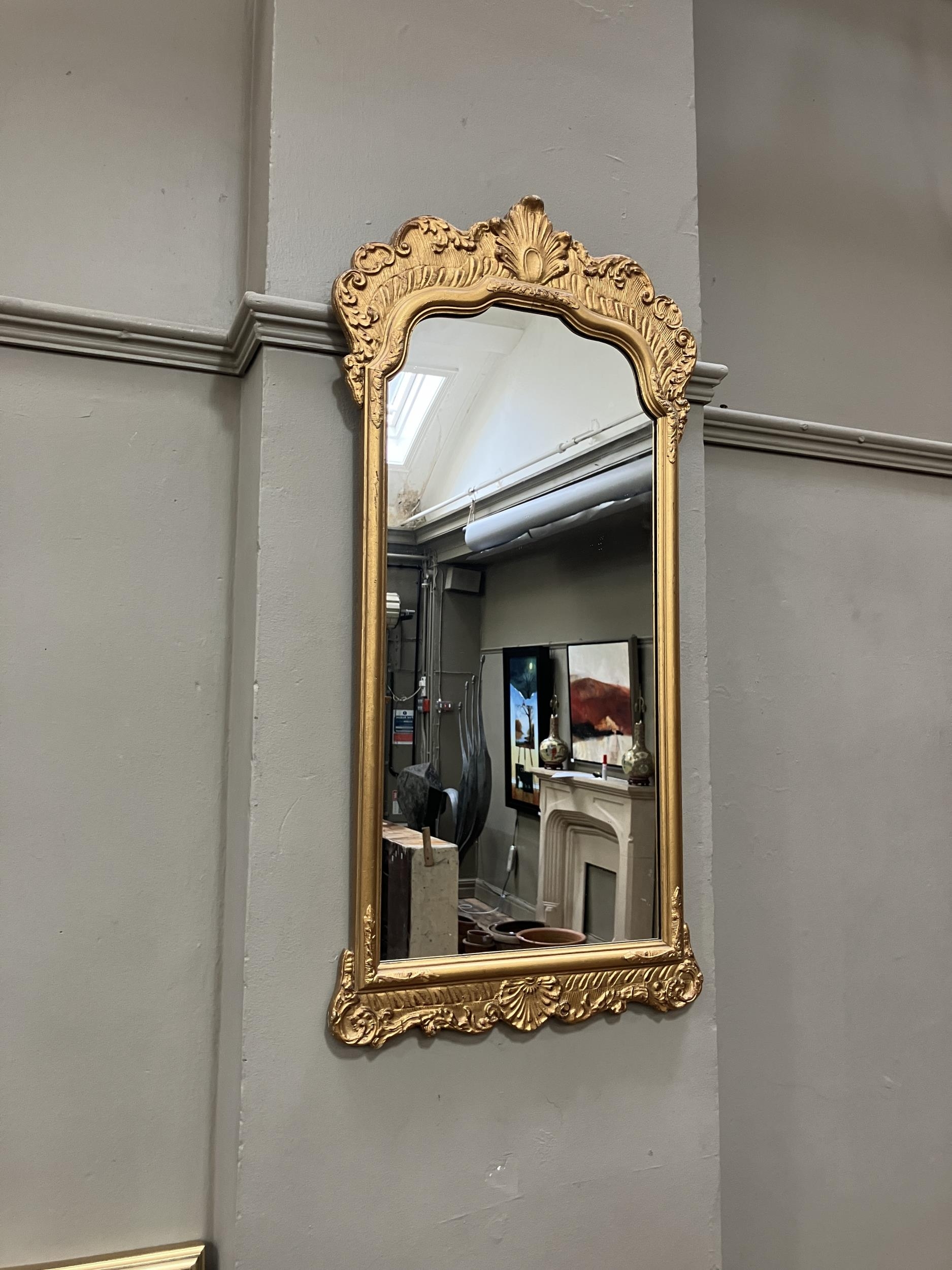 A gilt framed wall mirror of arched outline with foliate moulded pediment, 87cm x 45cm - Image 2 of 2