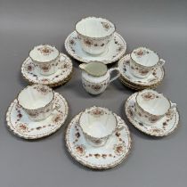 An early 20th century English tea service, transfer printed and enamelled with sways and cartouche