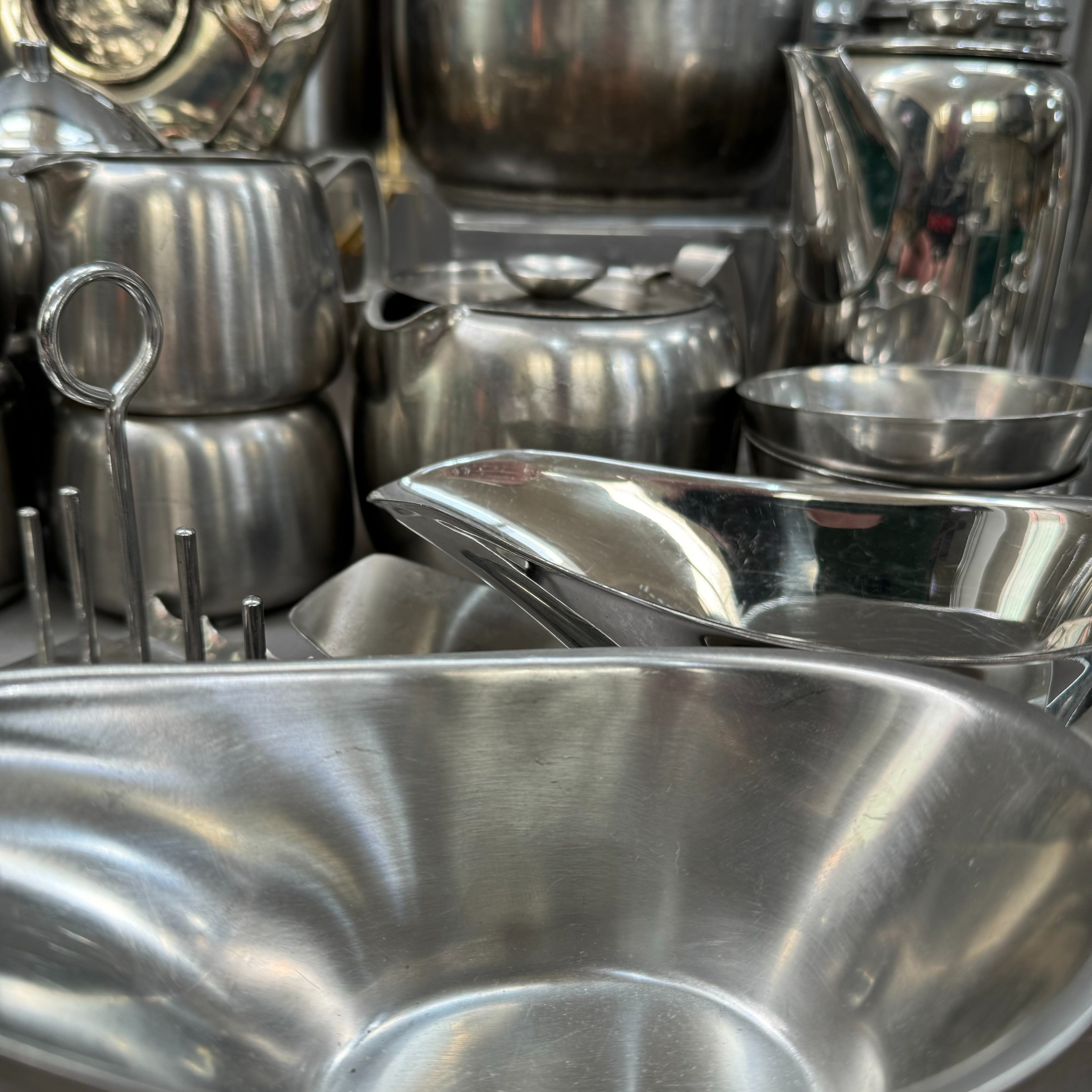 A large collection of stainless steel ware, teapot, hot water jug, coffee pot, storage jar, toast