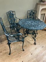 A green metal patio table and three armchairs