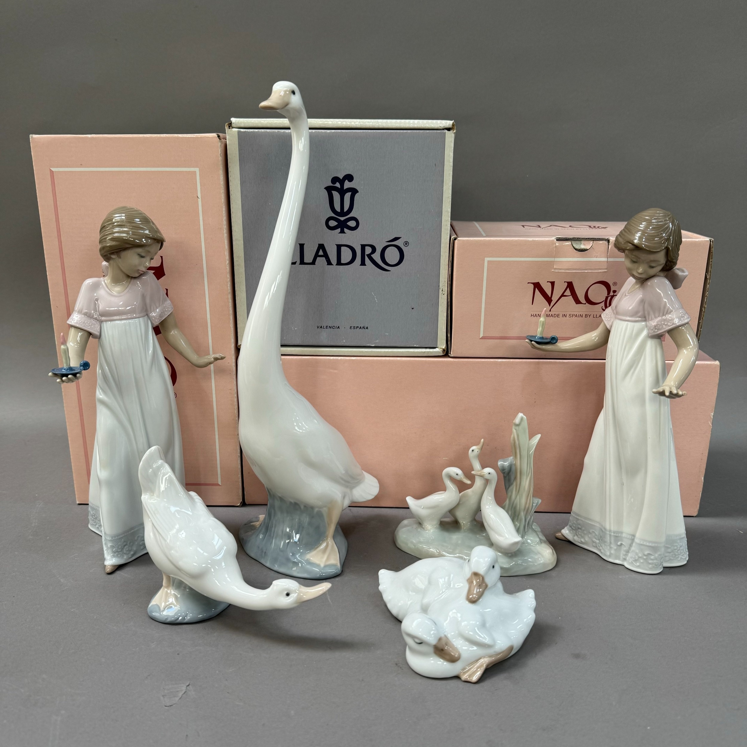 Two Nao figures, girl with candle measuring 26cm together with a figure of a goose 34cm and a