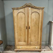 A Victorian pine two drawer armoire with arched profile with pierced pediment over two arch indented