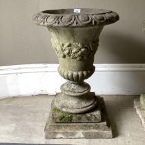 A cast garden urn having an egg and dart rim, foliate border and lower lobed body on a bladed