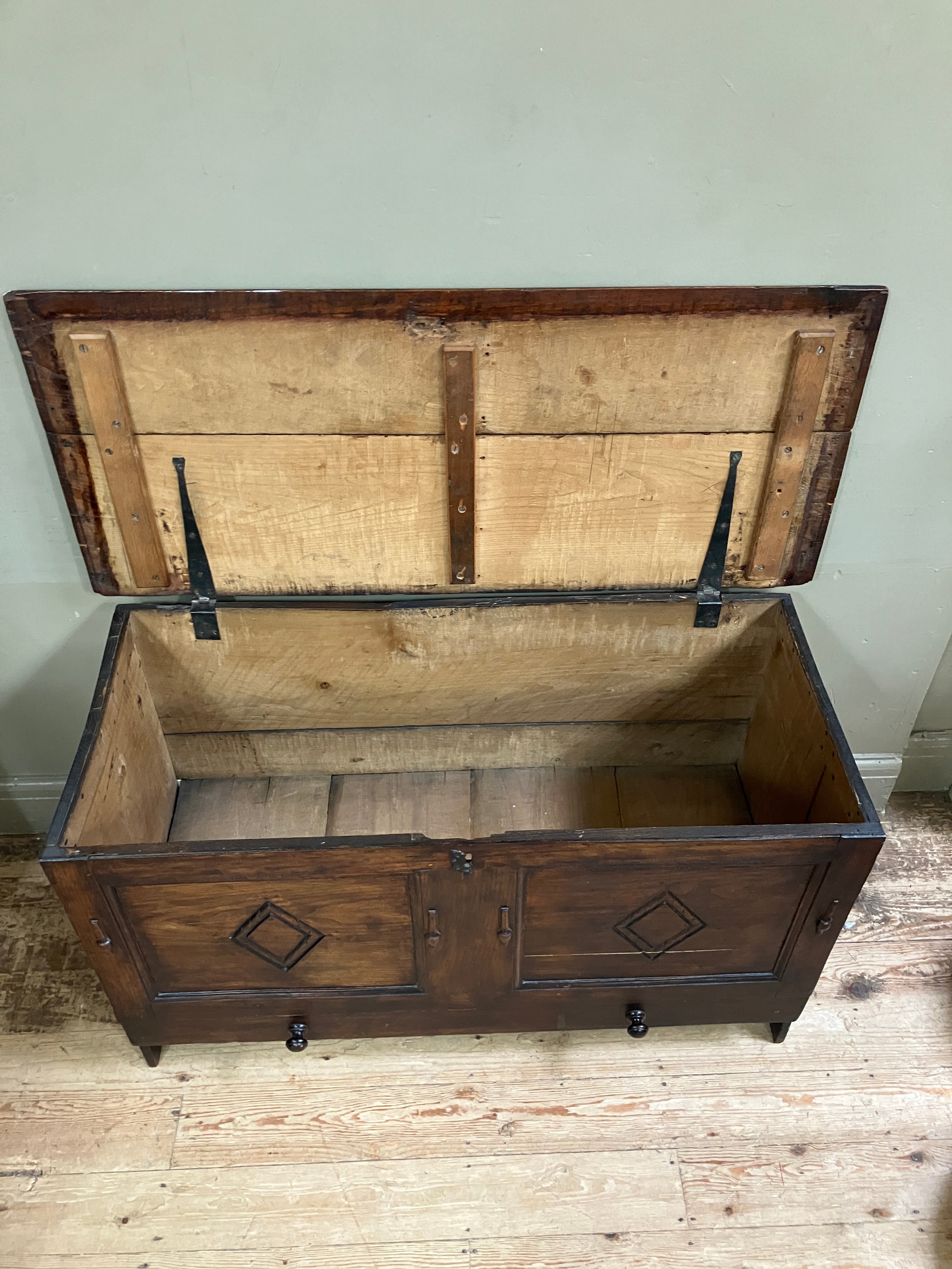 A 19th century oak kist having a twin indented panel front with diamond motifs on panel shaped