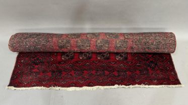 A Bokara rug, the red field filled with multiple medallions within a principle border of panelled