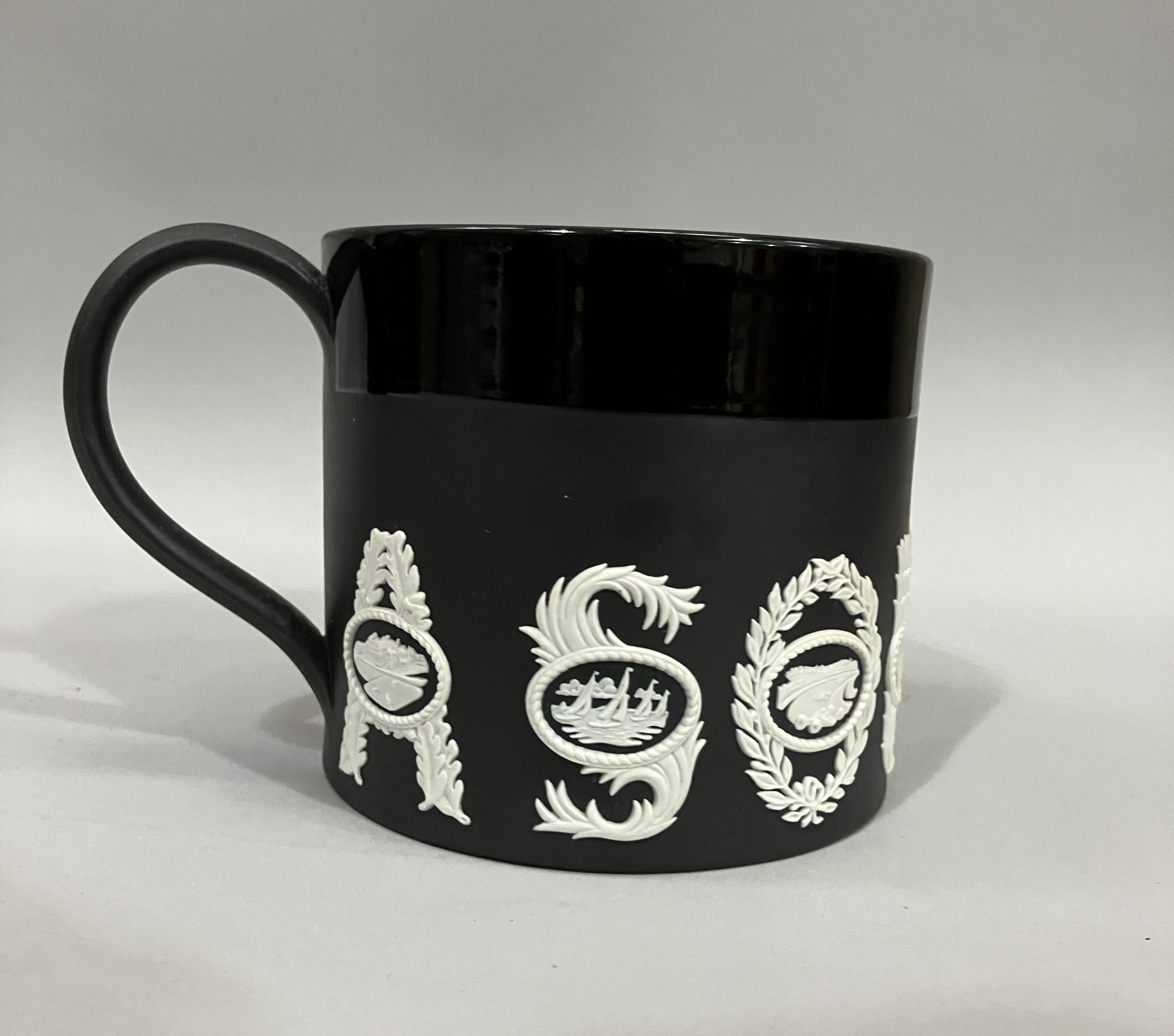 Richard Guyatt for Wedgwood, black basalt 'Sporting Mug' with white sprigging, no. 196/500, 10.5cm