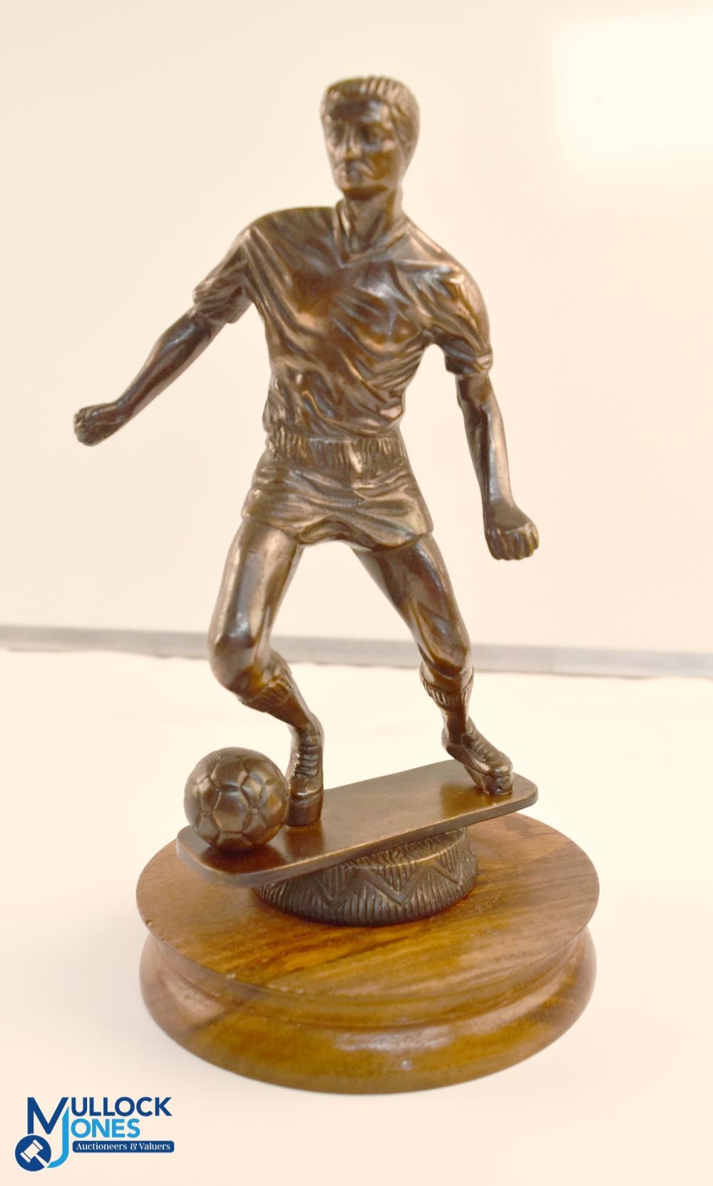 A bronze football statue on a wooden plinth. Size 9'' height, 5'' diameter base.