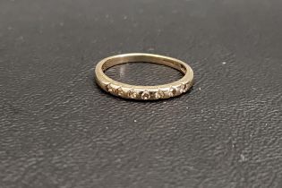 DIAMOND SET NINE CARAT GOLD BAND with seven flush set diamonds, ring size J and approximately 1.4