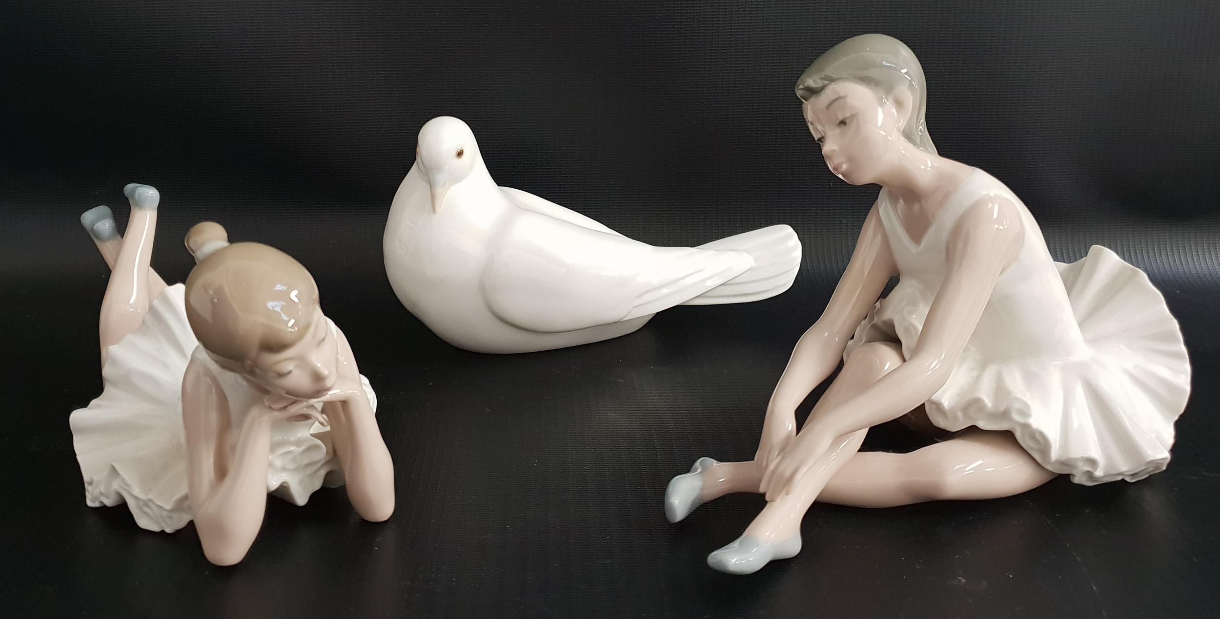 THREE NAO FIGURINES comprising a seated ballerina adjusting her shoe, 14cm high, a ballerina lying