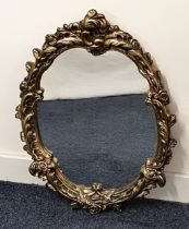 OVAL WALL MIRROR in a shaped gilt frame with a plain plate, 61.5cm x 45cm