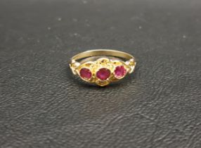 PRETTY RUBY THREE RINE RING on nine carat gold shank with shaped and pierced setting, ring size M