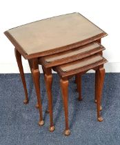 WALNUT NEST OF TABLES with glass tops, standing on cabriole supports, 52.5cm high