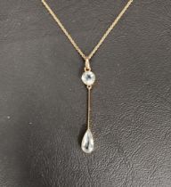 EDWARDIAN AQUAMARINE SET PENDANT the round cut aquamarine above a knife edge bar and further pear