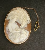 LARGE CARVED SHELL CAMEO BROOCH in pinchbeck mount, the oval cameo depicting a woman feeding a