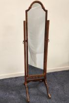 WALNUT CHEVAL MIRROR with an arched plain plate, standing on splayed supports, 158cm high