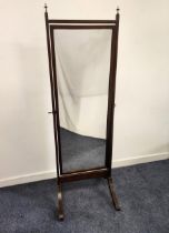 MAHOGANY CHEVAL MIRROR with a rectangular plate, the supporting columns with turned metal finials,