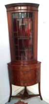 19th CENTURY MAHOGANY AND INLAID BOW FRONT FREE STANDING CORNER CABINET with a moulded cornice above