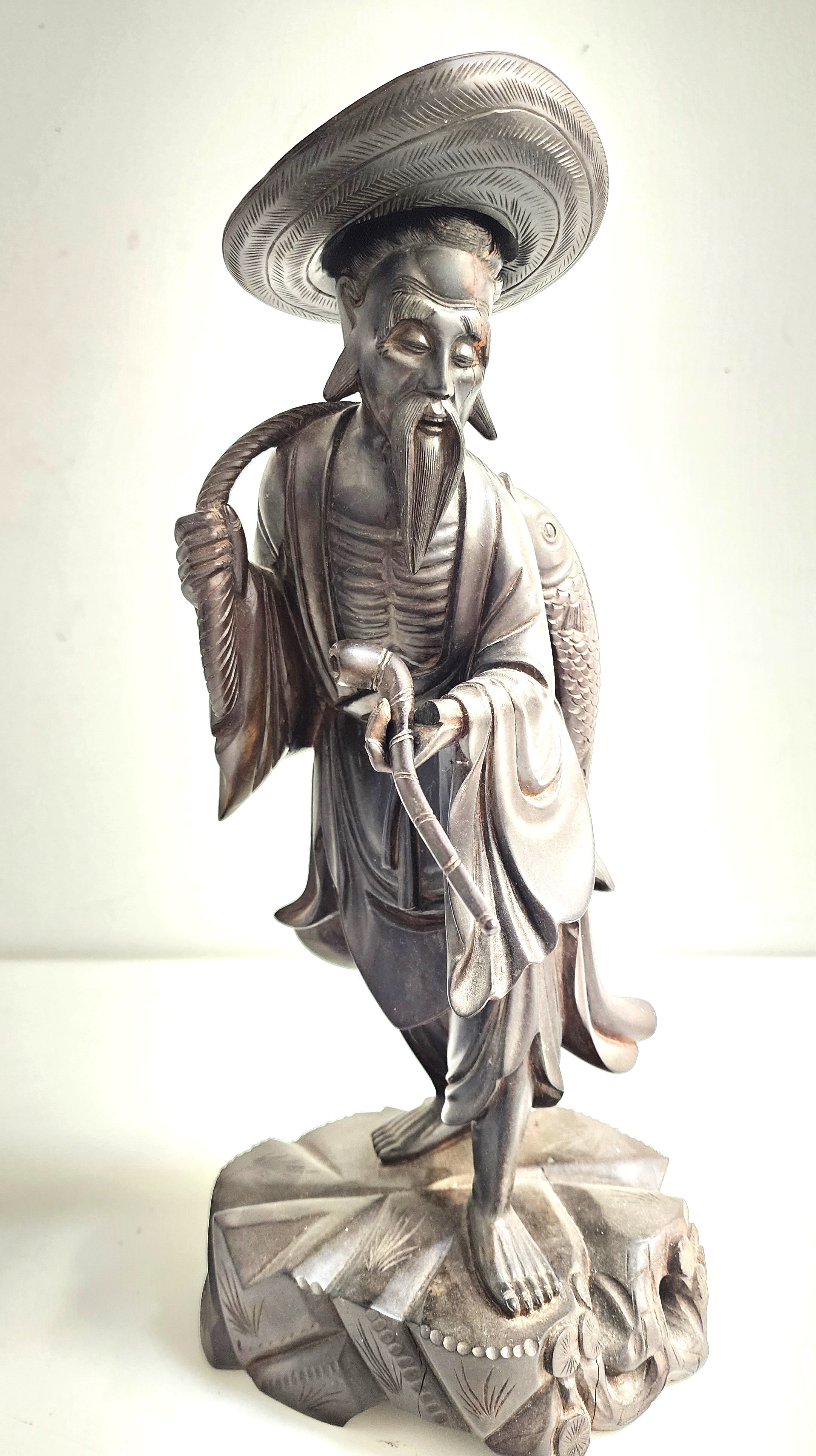 EARLY 20th CENTURY CHINESE CARVED WOOD FIGURE depicting a fisherman with a fish being carried on his