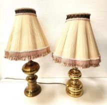 TWO BRASS TABLE LAMPS both with turned bulbous bodies, with pleated tapering shades with tassels,